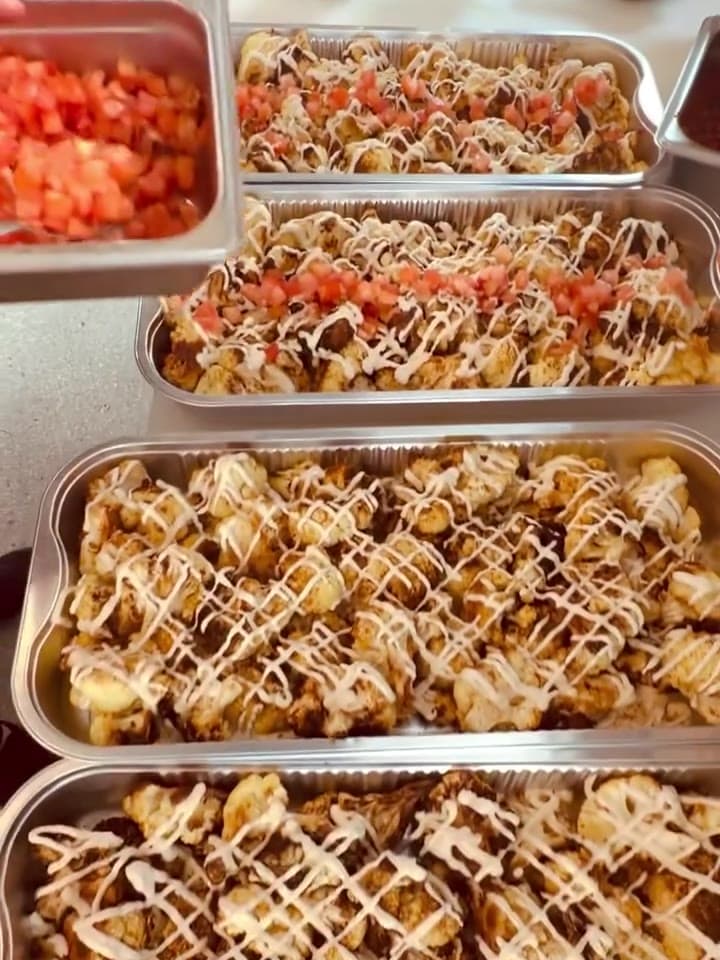Roasted cauliflower trays, plated for a catering order.